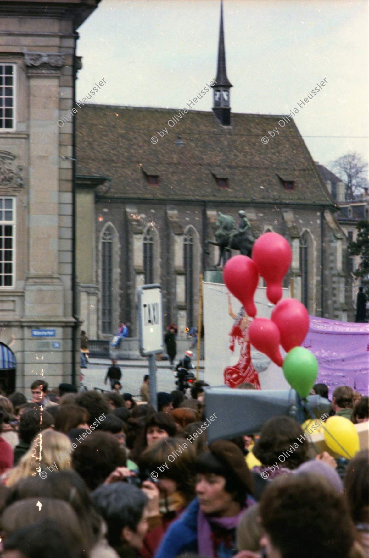 Image of sheet 19790020 photo 34: FBB Demonstration für Frauen und eine Mutterschaftsversicherung 'Seid Realisten fordert das Unmögliche' Mutterschaftschutz ein Fremdwort' Frauenbefreiungsbewegung 
Zürich 1979 Schweiz Switzerland women fight protest Street Münsterplatz Wasserkirche Limmat Ballon rot