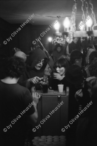 Image of sheet 19800020 photo 10: Luzerner Fasnacht. Olivia  Weinbergstr. 37, mit weisser Maske und Hut. Masken Bürger feiern Fasnacht in Restaurant. Larven. Violinen Spieler.Nachtstimmung mit Lichter. Telefonieren in Telefon Zelle. 1980 Schweiz Switzerland culture