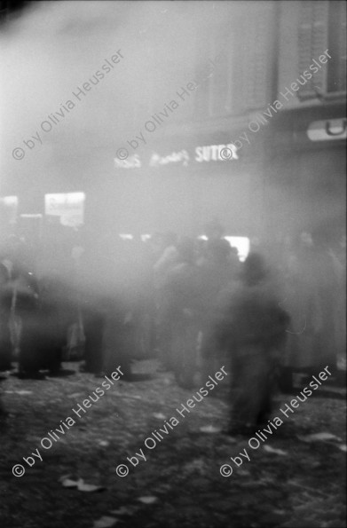 Image of sheet 19800020 photo 34: Luzerner Fasnacht. Olivia  Weinbergstr. 37, mit weisser Maske und Hut. Masken Bürger feiern Fasnacht in Restaurant. Larven. Violinen Spieler.Nachtstimmung mit Lichter. Telefonieren in Telefon Zelle. 1980 Schweiz Switzerland culture