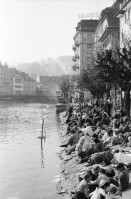 Image of sheet 19800030 photo 36: Fasnächtler sitzen am Ufer der Reuss. Luzerner Fasnacht bei Tag. 1980 Schweiz Luzern