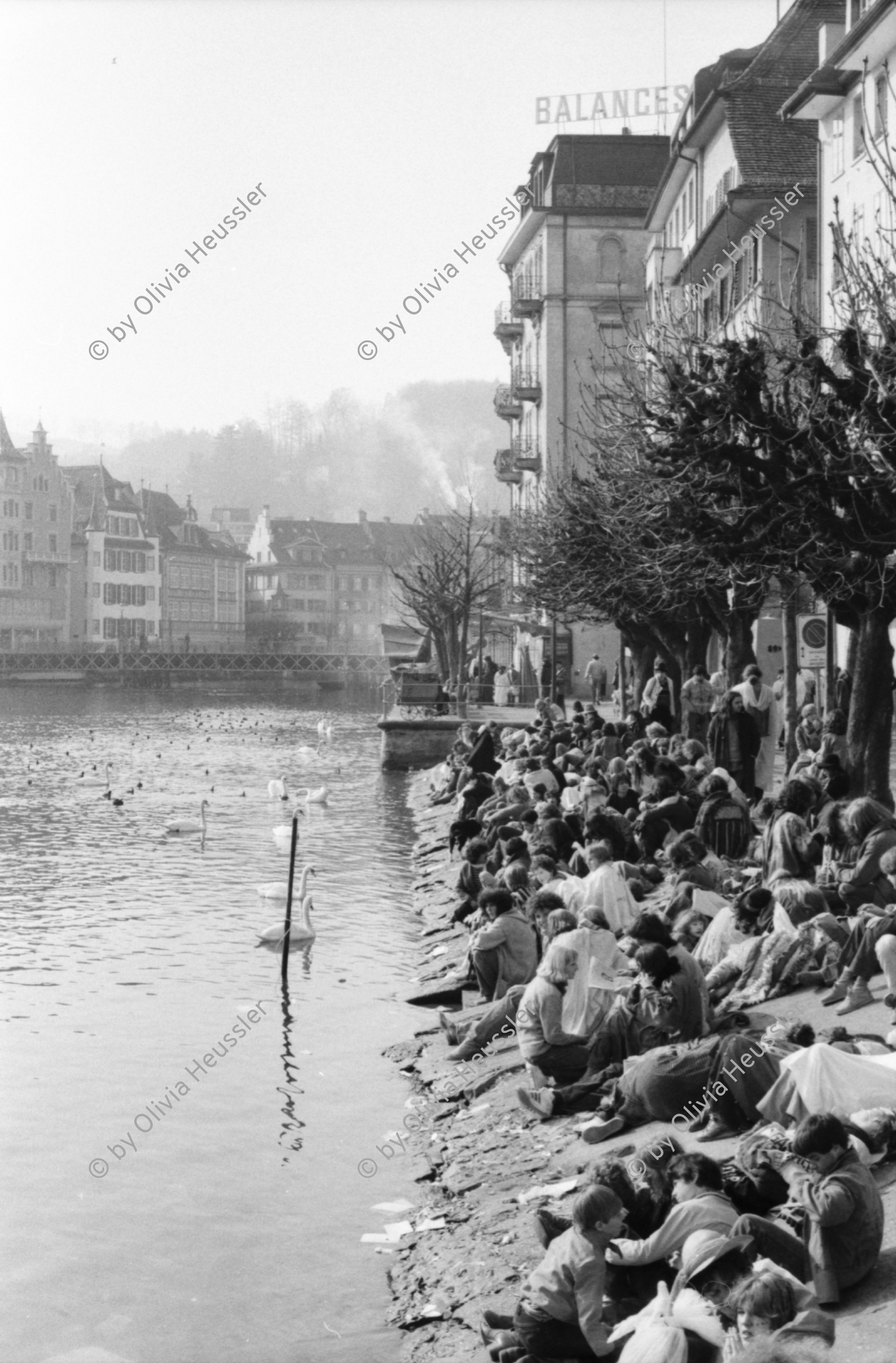 Image of sheet 19800030 photo 36: Fasnächtler sitzen am Ufer der Reuss. Luzerner Fasnacht bei Tag. 1980 Schweiz Luzern