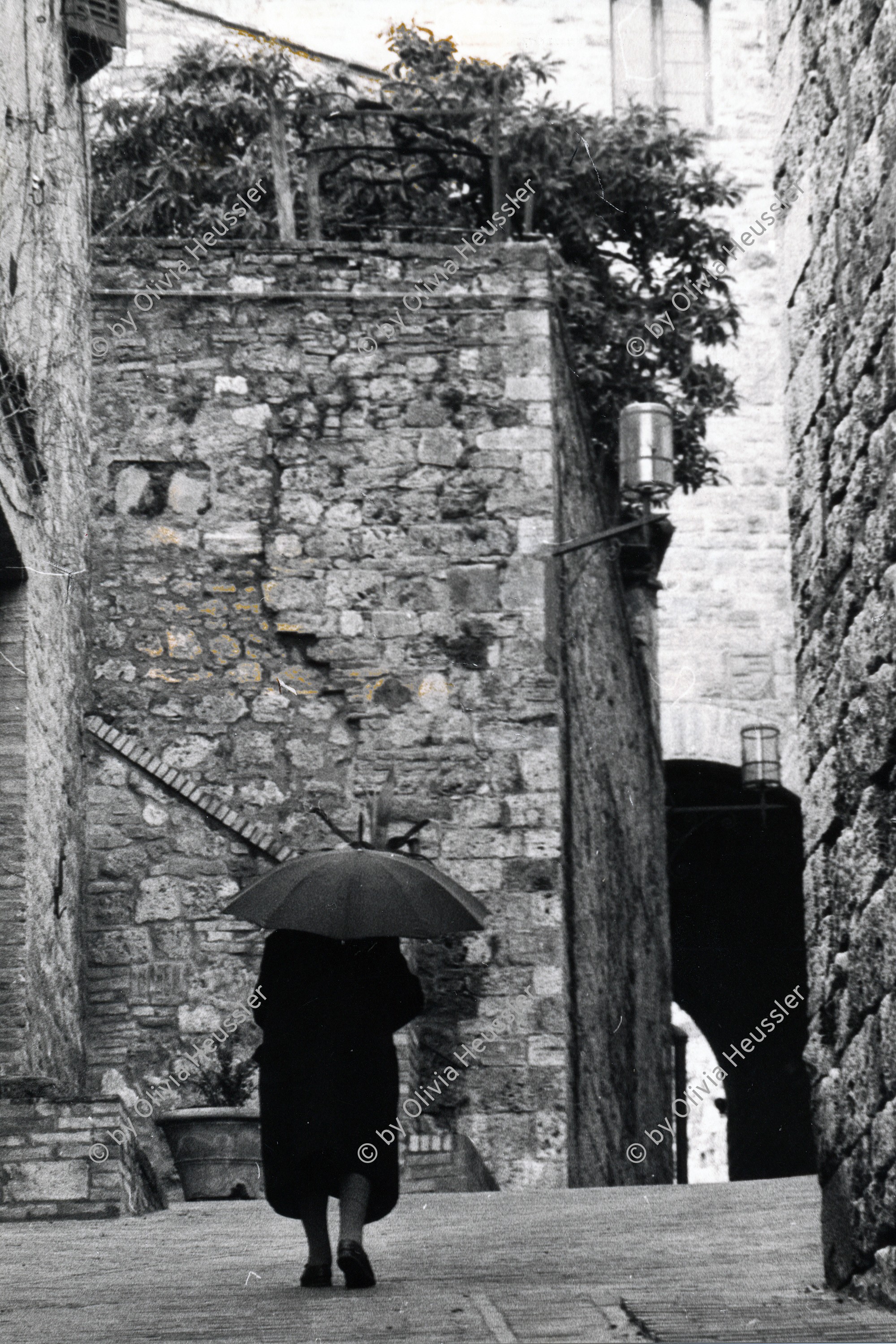 Image of sheet 19800042 photo 13: mit geöffnetem Regenschirm von oben. Architektur  Gasse. Italien Italy San Giminiano 1980 √