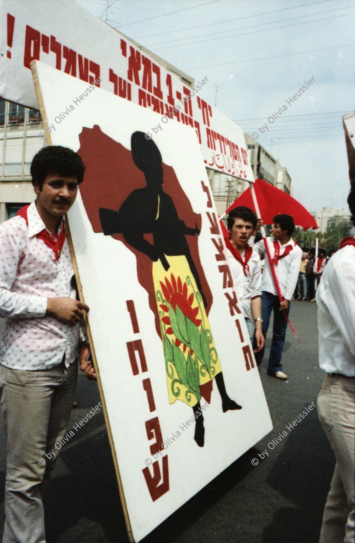 Image of sheet 19800100 photo 20: An der 1. Mai Demonstration Feier in Tel Aviv Israel Kibutznik nehmen 150'000 Menschen teil. Viele junge Frauen und Männer Chaverim aus den Kibutz nehmen teil.
Der Wagen der komunistischen Partei Israels trägt das Emblem mit Sichel und Hammer 1980