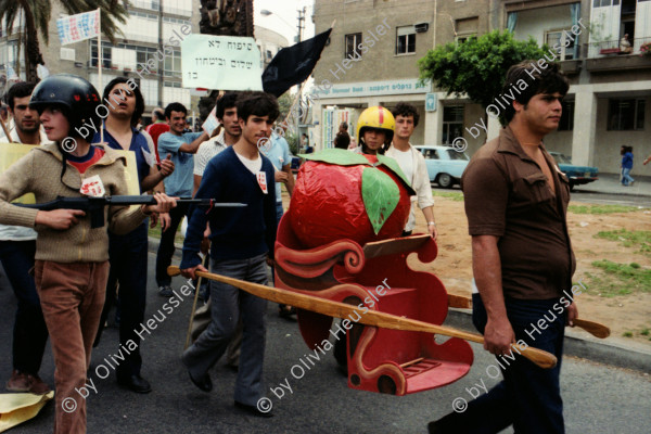 Image of sheet 19800100 photo 31: An der 1. Mai Demonstrations Feier 1980, in Tel Aviv Israel, nehmen 150'000 Menschen teil,  junge Frauen und Männer aus den Kibutz. Sie tragen eine grosse Tomate aus Papier maché mit. Waffe Gewehr
√
A kibbutz (Hebrew: קִבּוּץ / קיבוץ, lit. "gathering, clustering"; plural kibbutzim) is a collective community in Israel that was traditionally based on agriculture. Today, farming has been partly supplanted by other economic branches, including industrial plants and high-tech enterprises.[1] Kibbutzim began as utopian communities, a combination of socialism and Zionism. In recent decades, some kibbutzim have been privatized and changes have been made in the communal lifestyle. A member of a kibbutz is called a kibbutznik (Hebrew: קִבּוּצְנִיק).