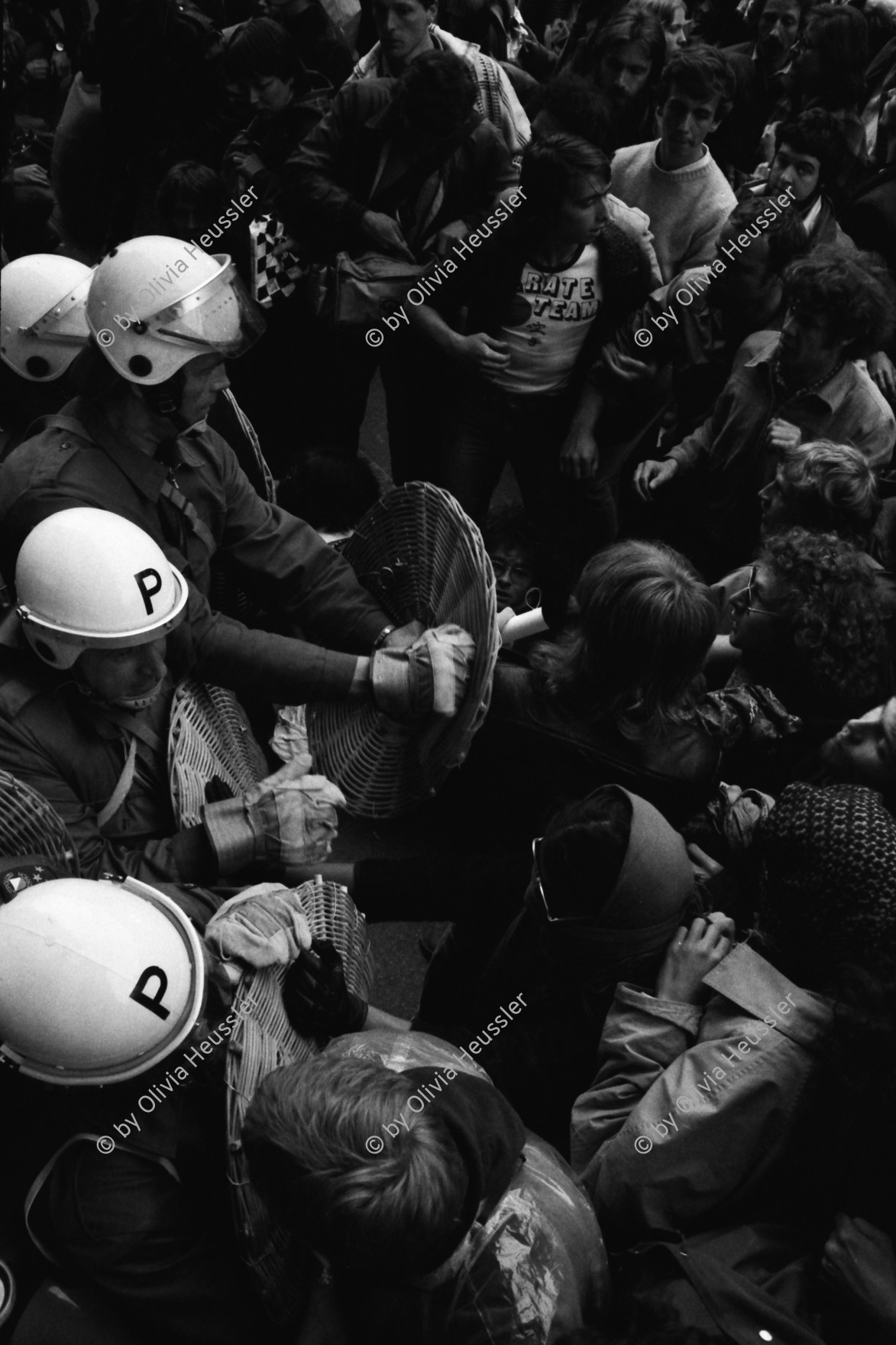 Image of sheet 19800160 photo 34: Demonstrierende versammeln sich vor dem Rathaus: Sie fordern den Gemeinderat zu einer Diskussion auf. Der Gemeinderat verweigert das Gespräch. Die Demonstrierenden harren aus, worauf die Polizei eingreift.
Zur Forderung eines Autonomen Jugendhauses wird der Platz vor dem Rathaus am Limmatquai besetzt. Polizei Einsatz. Polizeihelme von oben herab.

Jugendbewegung Bewegig AJZ Zürcher Jugendunruhen Demonstrationen
Zürich Youth movement protest Police helmets 1980
copyright by Olivia Heussler √