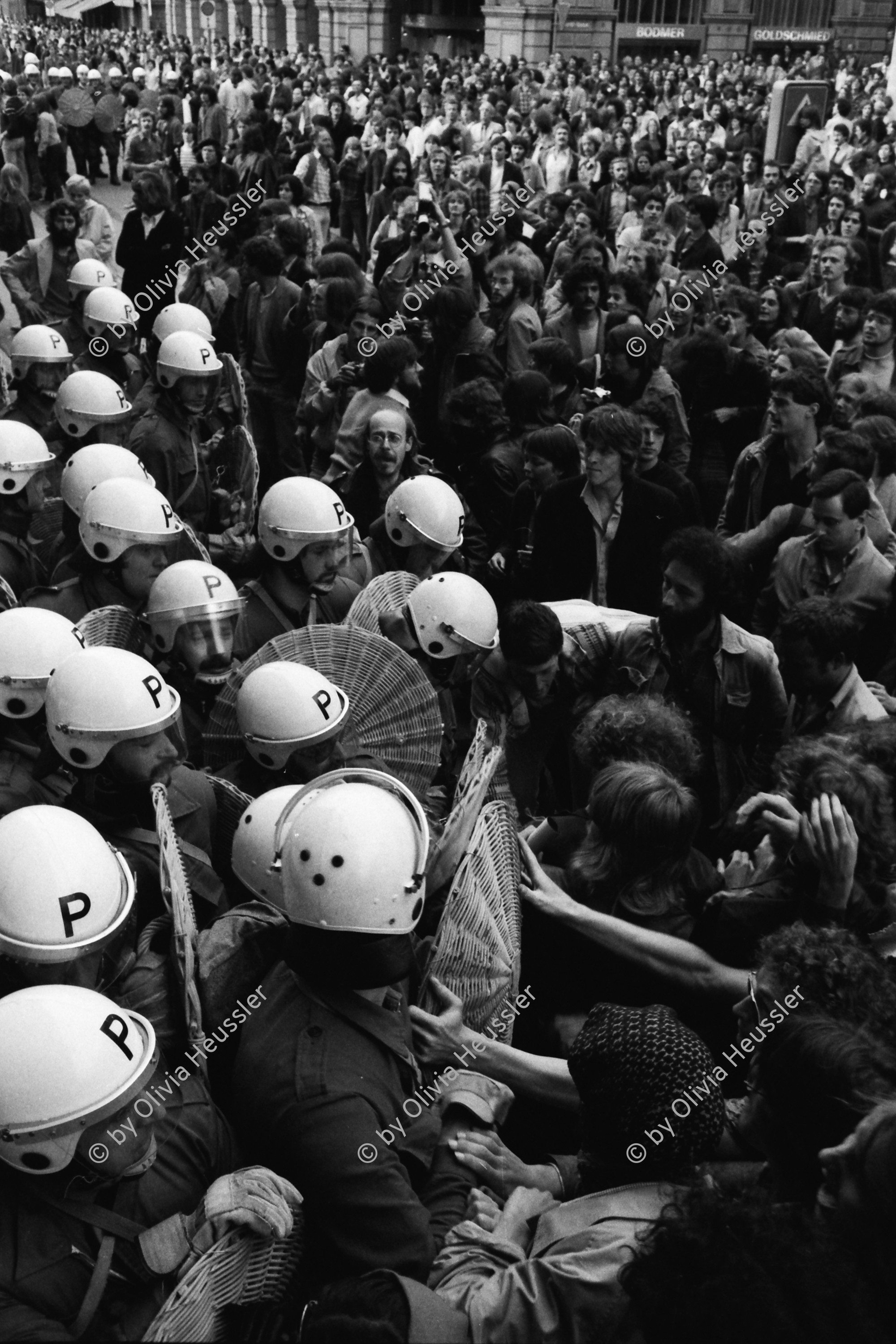 Image of sheet 19800160 photo 37: Demonstrierende versammeln sich vor dem Rathaus: Sie fordern den Gemeinderat zu einer Diskussion auf. Der Gemeinderat verweigert das Gespräch. Die Demonstrierenden harren aus, worauf die Polizei eingreift. 
Zur Forderung eines Autonomen Jugendhauses wird der Platz vor dem Rathaus am Limmatquai besetzt. Sit-In. Die PolitikerInnen ausgefragt und angepöbelt.  Polizei Einsatz. Polizeihelme von oben herab. 

Jugendbewegung Bewegig AJZ Zürcher Jugendunruhen Demonstrationen
Zürich Protest Youth movement 1980 √
copyright by Olivia Heussler