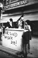 Image of sheet 19800180 photo 2: Jugendliche vor dem Café Odeon, Bellevue, Zuerich 1980. 
Mir sind wider da ! spray Graffiti auf dem Transformatorenhäuschen mit Mascotte Puppe und Paar.
Jugendbewegung Bewegig Zürcher Jugendunruhen Demonstrationen youth movement protest  Schweiz Switzerland

Exhibitions:
Couvrage-Action. Zürcher Künstler, Züspa, Zürich 1980. On Resin Coated Paper with sulphur toning
Belgrade Photo Month 2019
Im Bestand Fotostiftung Schweiz 24 x 30 cm RC Vintage 1986.018 B.0226