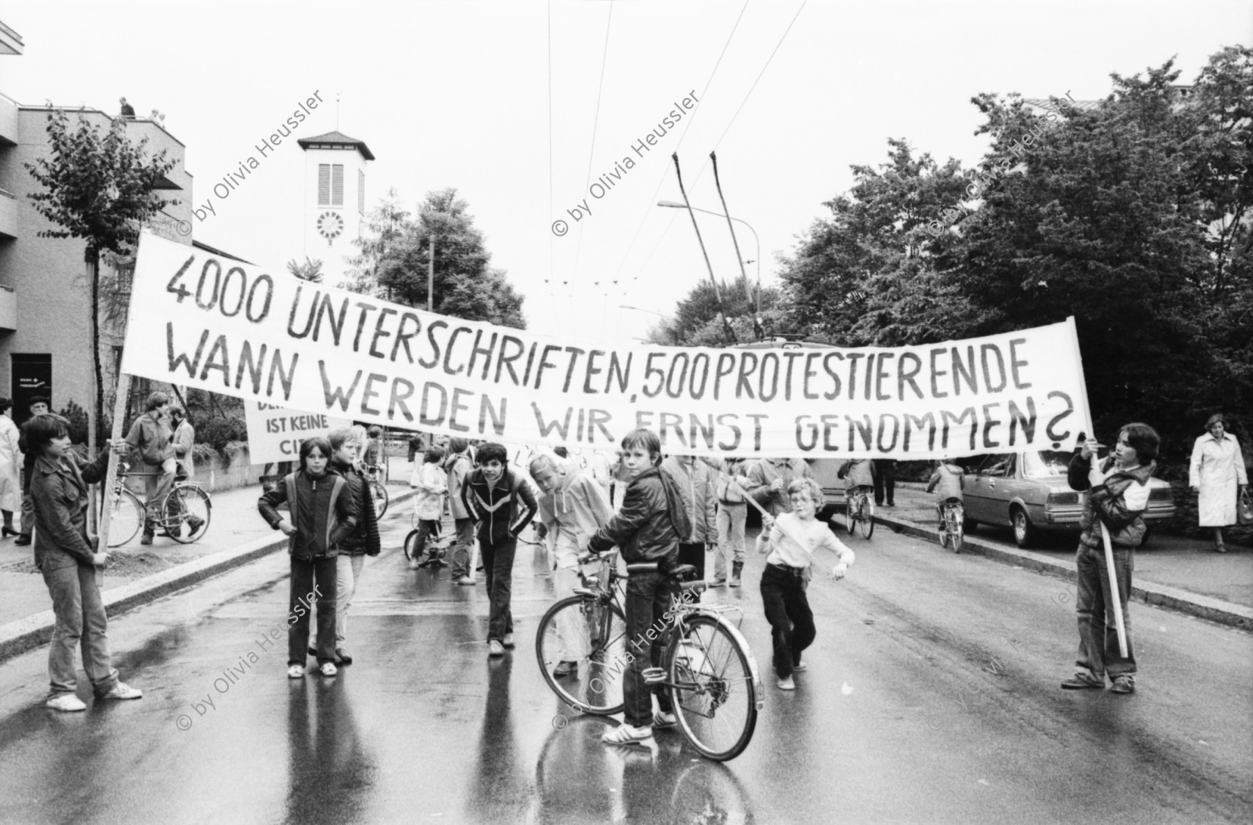 Image of sheet 19800261 photo 6: Kinder und AnwohnerInnen Protest gegen zuviel Verkehr an der Schweighofstrasse, Zürich, 1980.
Demonstration Strassenverkehr