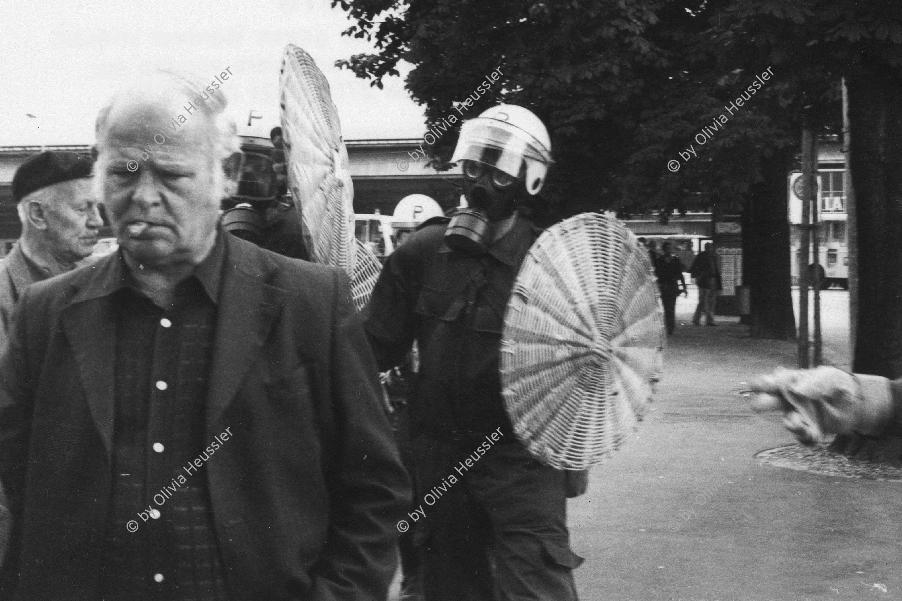 Image of sheet 19800301 photo 11: Vor dem AJZ versammeln sich rund 200 Personen, um für die Einstellung der Strafverfahren zu demonstrieren. Der unbewilligte Demonstrationszug wird von der Polizei aufgelöst: Massive Auseinandersetzungen zwischen den Bewegten und der Polizei, die bis am Sonntagmorgen andauern. Mehr als hundert Personen werden verhaftet. In der folgenden Woche wird in den Medien über das polizeiliche Vorgehen heftig diskutiert.
Leute kriegen Panik und flüchten vor dem AJZ für Demo gegen Isolationshaft greifen Polizeigrenadiere die Leute mit Tränengas Einsatz an. Auch alte Menschen flüchten. durch Tränengasnebel. 
Jugendbewegung Bewegig AJZ Zürcher Jugendunruhen Demonstrationen
Zürich youth movement protest 1980 √