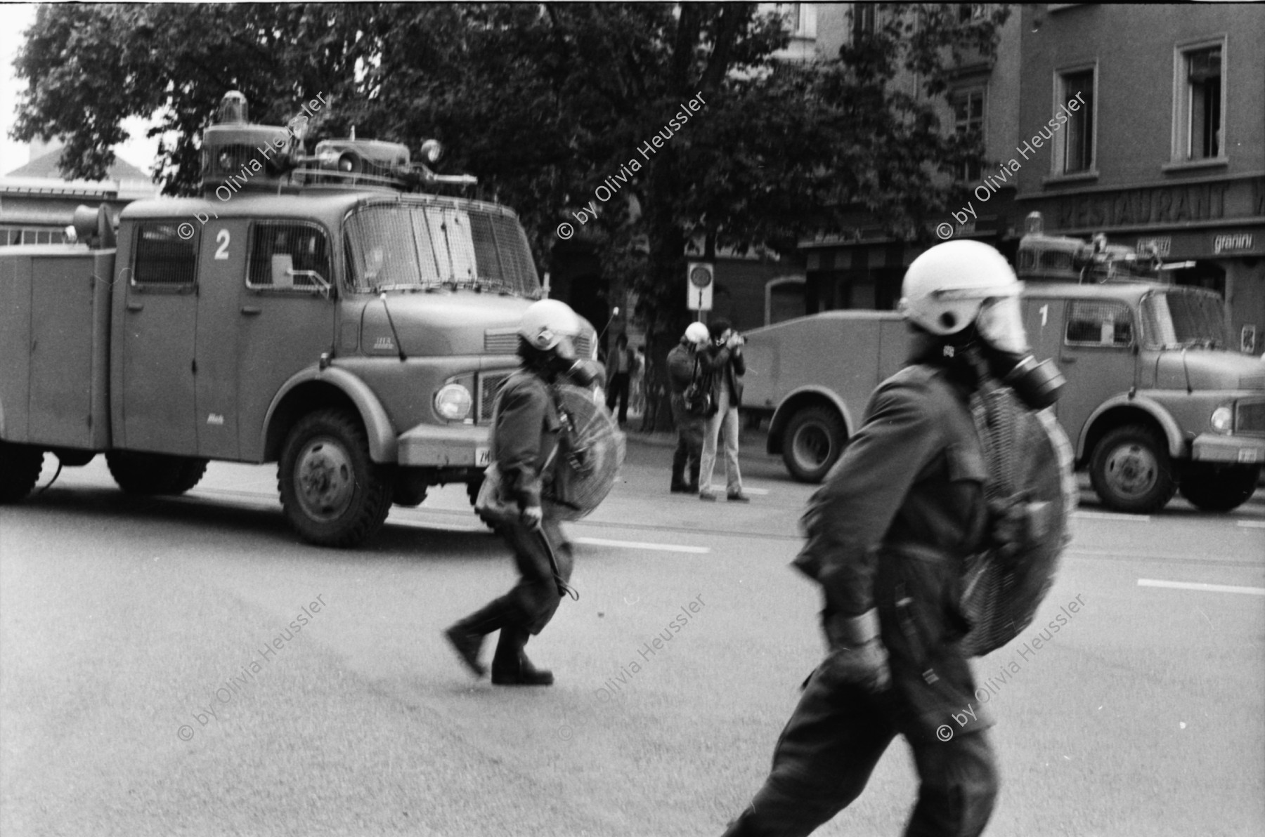 Image of sheet 19800301 photo 13: Vor dem AJZ versammeln sich rund 200 Personen, um für die Einstellung der Strafverfahren zu demonstrieren. Der unbewilligte Demonstrationszug wird von der Polizei aufgelöst: Massive Auseinandersetzungen zwischen den Bewegten und der Polizei, die bis am Sonntagmorgen andauern. Mehr als hundert Personen werden verhaftet. In der folgenden Woche wird in den Medien über das polizeiliche Vorgehen heftig diskutiert.
Das Autonome Jugendzentrum wird ganz mit Tränengas eingeräuchert. Leute kriegen Panik und flüchten auf Dach des AJZ Nach einer Besammlung vor dem AJZ für Demo gegen Isolationshaft greifen Polizeigrenadiere die Leute mit Tränengas Einsatz an. Auch alte Menschen flüchten. Psychoanalytiker und Kunstmaler Fritz Morgenthaler. (Vater von Jan und Marc Morgenthaler ) flüchtet durch Tränengasnebel. Ein Mann versucht mit der Polizei zu verhandeln. 
Titelbild Film Top. UNICEF Wasserwerfer
Jugendbewegung Bewegig AJZ Zürcher Jugendunruhen Demonstrationen
Zürich youth movement protest 1980