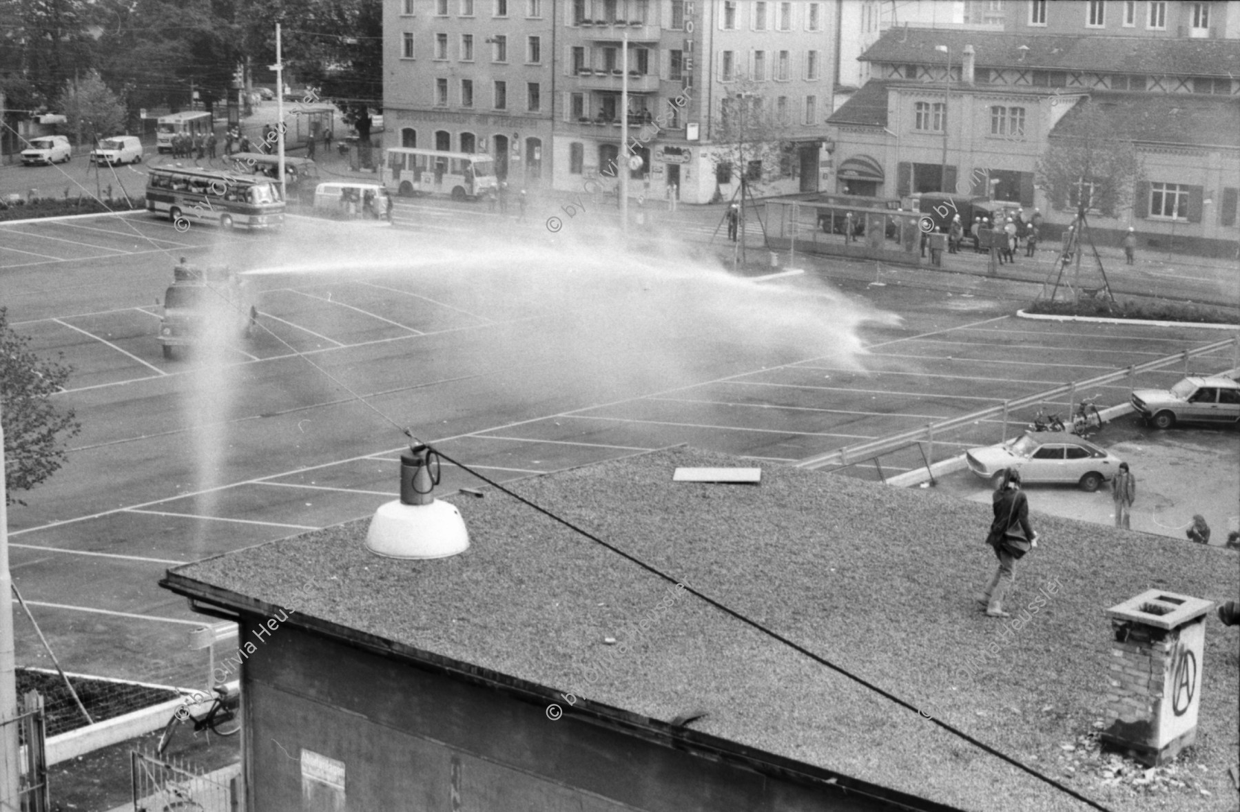 Image of sheet 19800305 photo 21: Vor dem AJZ versammeln sich rund 200 Personen, um für die Einstellung der Strafverfahren zu demonstrieren. Der unbewilligte Demonstrationszug wird von der Polizei aufgelöst: Massive Auseinandersetzungen zwischen den Bewegten und der Polizei, die bis am Sonntagmorgen andauern. 124 Personen werden verhaftet. In der folgenden Woche wird in den Medien über das polizeiliche Vorgehen heftig diskutiert. 
12 Stunden Demonstration. Das AJZ ist vollständig mit Tränengas und Rauch eingehüllt. Auf dem Dach flüchten Leute, die direkt angespritzt werden aus dem Wasserwerfer mit Tränengas Gemisch. Verletzter wird weggetragen. Leute wollen vom Dach springen.
Jugendbewegung Bewegig Zürcher Jugendunruhen Demonstrationen
Zürich youth movement protest 1980 teargas police panic Limmatstrasse Kreis fünf Schweiz Switzerland Europe