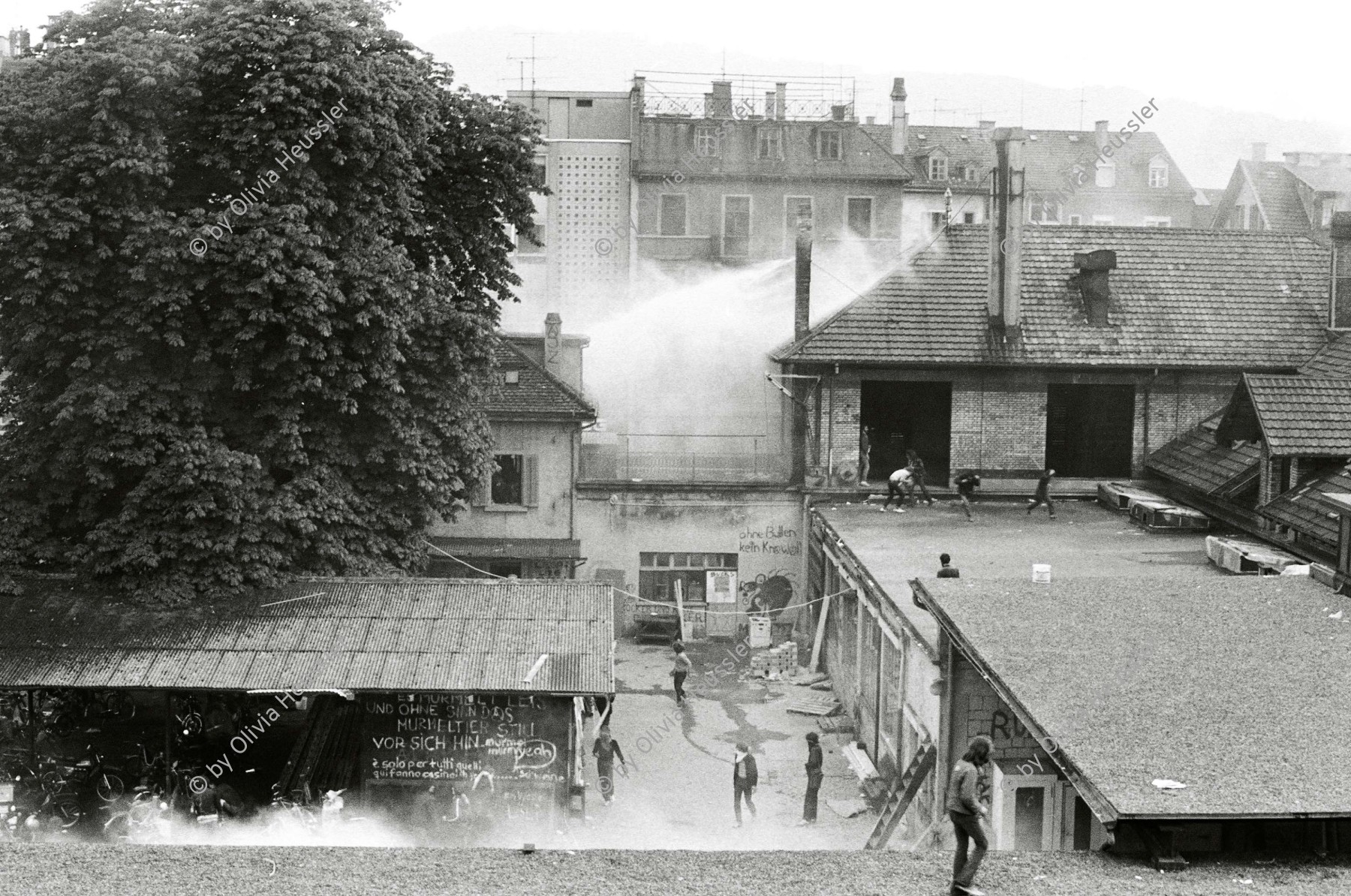 Image of sheet 19800305 photo 33: Vor dem AJZ versammeln sich rund 200 Personen, um für die Einstellung der Strafverfahren zu demonstrieren. Der unbewilligte Demonstrationszug wird von der Polizei aufgelöst: Massive Auseinandersetzungen zwischen den Bewegten und der Polizei, die bis am Sonntagmorgen andauern. 124 Personen werden verhaftet. In der folgenden Woche wird in den Medien über das polizeiliche Vorgehen heftig diskutiert. 
12 Stunden Demonstration. Das AJZ ist vollständig mit Tränengas und Rauch eingehüllt. Auf dem Dach flüchten Leute, die direkt angespritzt werden aus dem Wasserwerfer mit Tränengas Gemisch. Verletzter wird weggetragen. Leute wollen vom Dach springen.
Jugendbewegung Bewegig Zürcher Jugendunruhen Demonstrationen
Zürich youth movement protest 1980 √ liberation teargas police panic Limmatstrasse Kreis fünf Schweiz Switzerland Europe