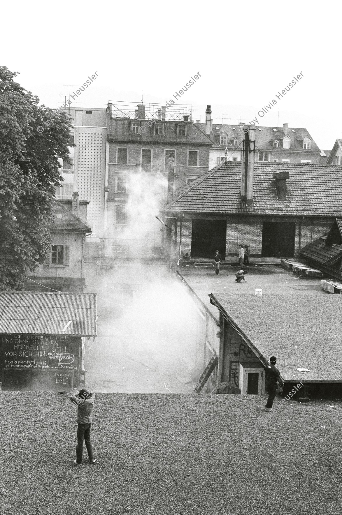 Image of sheet 19800305 photo 37: Vor dem AJZ versammeln sich rund 200 Personen, um für die Einstellung der Strafverfahren zu demonstrieren. Der unbewilligte Demonstrationszug wird von der Polizei aufgelöst: Massive Auseinandersetzungen zwischen den Bewegten und der Polizei, die bis am Sonntagmorgen andauern. 124 Personen werden verhaftet. In der folgenden Woche wird in den Medien über das polizeiliche Vorgehen heftig diskutiert. 
12 Stunden Demonstration. Das AJZ ist vollständig mit Tränengas und Rauch eingehüllt. Auf dem Dach flüchten Leute, die direkt angespritzt werden aus dem Wasserwerfer mit Tränengas Gemisch. Verletzter wird weggetragen. Leute wollen vom Dach springen.
Jugendbewegung Bewegig Zürcher Jugendunruhen Demonstrationen
Zürich youth movement protest 1980 √ liberation teargas police panic Limmatstrasse Kreis fünf Schweiz Switzerland Europe