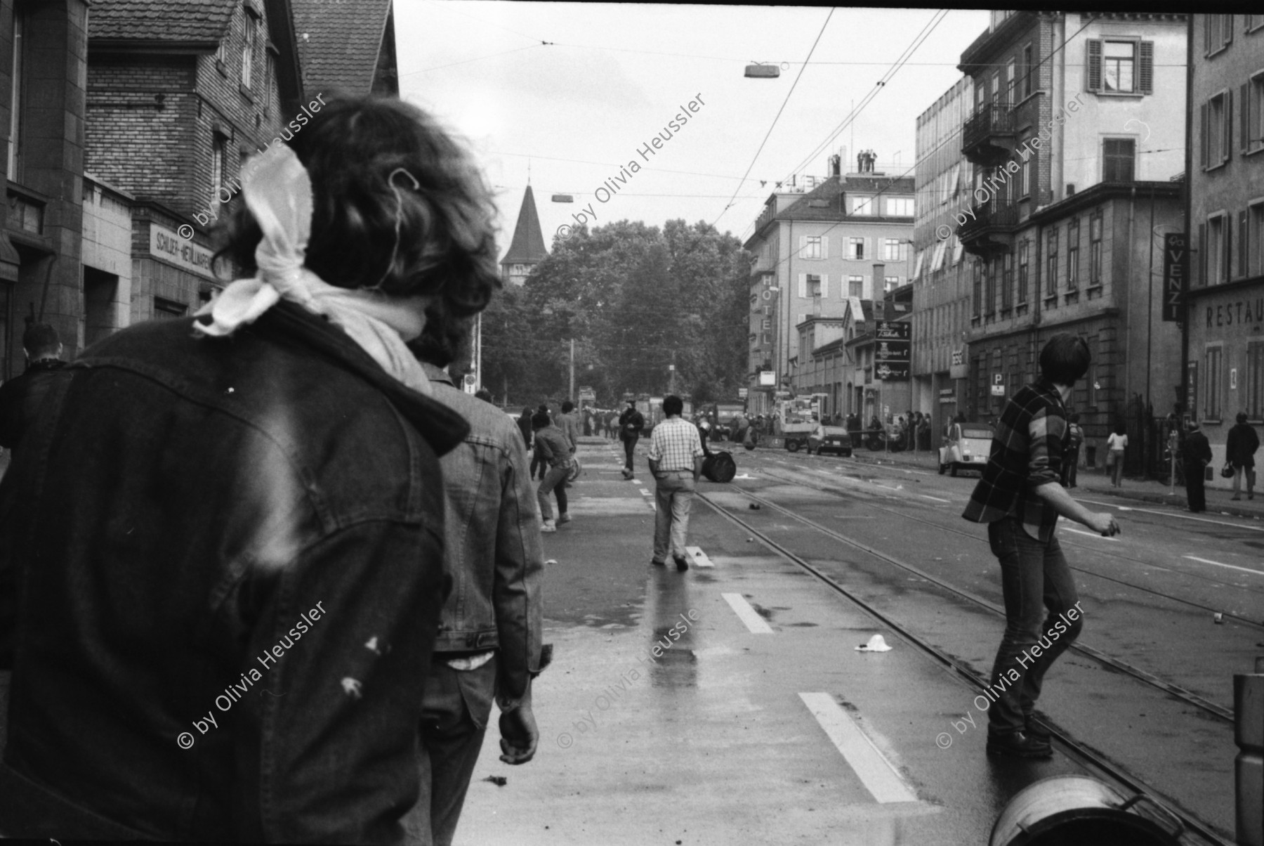 Image of sheet 19800306 photo 1: Demonstration für die Einstellung aller Strafverfahren. Zwölf Stunden Krawall  124 Verhaftungen Die Limmatstrasse 18-20 vor dem AJZ gleicht einem Schlachtfeld. Barrikaden. Rauch. Container liegen am Boden. Christian Vaterlaus.(heute Networking) Polizei greift Sanität Auto Deux Chevaux an, die Verletzte wegfahren, reissen Verwundete aus dem Auto und verhaften sie. Kamera Mann Ackermann von SFDRS. Junger Mann wird verhaftet, wird später Junkie und Patient von unserer Praxis am Limmatplatz. Angriff Polizei auf Gruppe auf Mühlesteg beim Platzspitz. Brücke über die Sihl. Junger schützt sich mit seinem aufgespannten Regenschirm. Wird von Polizei heftig zusammengeprügelt. Ich bin Zeugin am Prozess gegen ihn und erzähle über das friedliche Verhalten des Typs, der später 3 Monate bedingt Gefängnis kriegt. Meine Bilder (laut Staatsanwalt Bärtschi vor den Geschworenen) seien kein Beweis. Der Rand des Negativs sei nicht zu sehen!
Jugendbewegung Bewegig AJZ Zürcher Jugendunruhen Demonstrationen
Zürich youth movement protest 1980