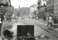 Image of sheet 19800306 photo 2: Vor dem AJZ versammeln sich rund 200 Personen, um für die Einstellung der Strafverfahren zu demonstrieren. Der unbewilligte Demonstrationszug wird von der Polizei aufgelöst: Massive Auseinandersetzungen zwischen den Bewegten und der Polizei, die bis am Sonntagmorgen andauern. 124 Personen werden verhaftet. In der folgenden Woche wird in den Medien über das polizeiliche Vorgehen heftig diskutiert.

Die Limmatstrasse vor dem AJZ gleicht einem Schlachtfeld. Barrikaden. Rauch. Container liegen am Boden. 12. Juli 1980
Zürich youth movement protest 1980 √ Kreis 5 fünf Schweiz Switzerland Europe
p.40