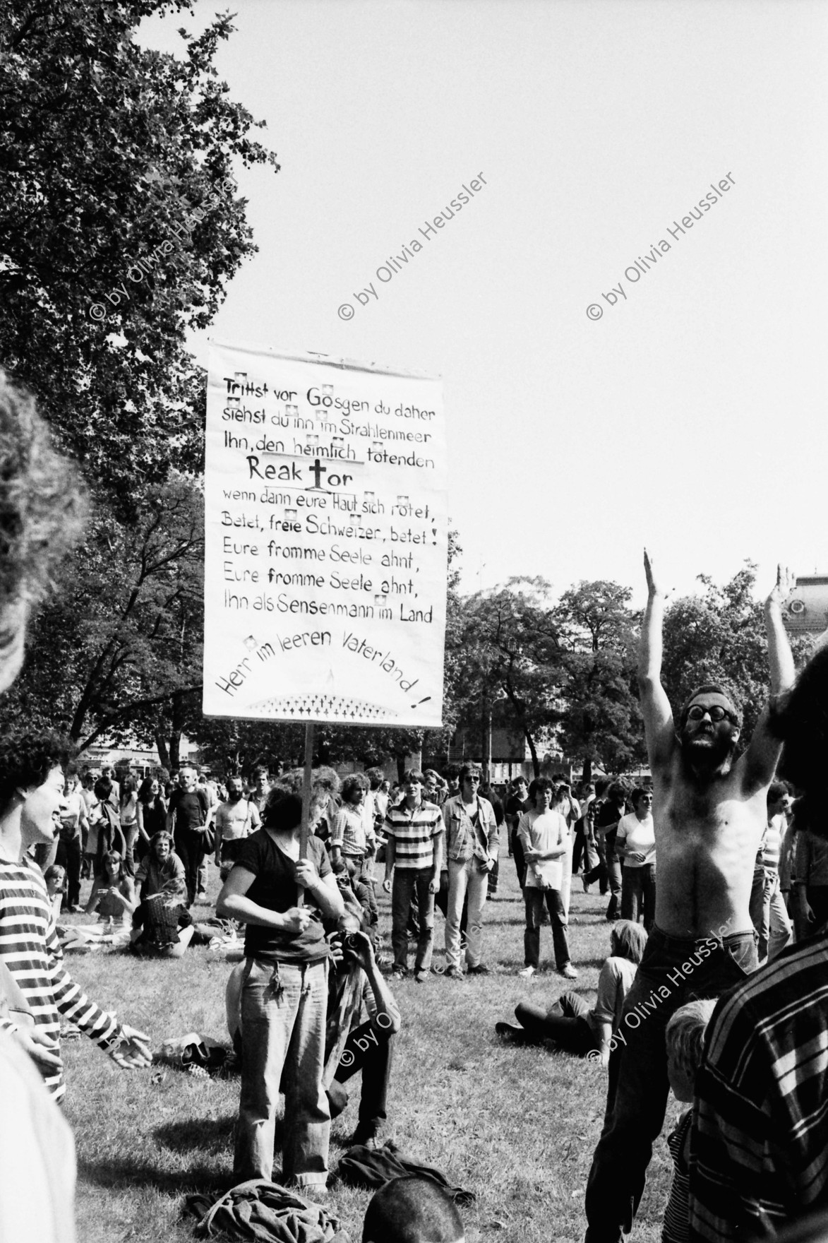 Image of sheet 19800322 photo 32: 1. August Fest auf dem Sechseläuten Platz mit anschliessender Unzufriedenen Demo.
Die Kollegen singen ein Lied auf das AKW Gösgen.

Trittst vor Gösgen du daher
siehst du ihn im Strahlenmeer
Ihn, den heimlich tötenden ReakTor
wann dann eure Haut sich rötet
Betet, freie Schweizer betet!
Eure fromme Seele ahnt,
Eure fromme Seele ahnt,
Ihn als Sensemann im Land
Herr im leeren Vaterland!

Chläusel (gest. 2012)

Zürich youth movement protest 1980 √
© 1980, by OLIVIA HEUSSLER, / www.clic.li