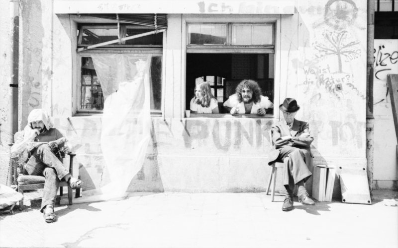 Image of sheet 19800322 photo 8: Ein Rentner und Jugendliche sitzen im Autonomen Jugendzentrum (AJZ) an der Sonne am 1. August 1980 dem Schweizer Nationalfeiertag. 
Jugendbewegung Bewegig AJZ Zürcher Jugendunruhen 
Zürich youth movement protest 1980
Der Mann heisst Hugo Sax Jhrg. 1922