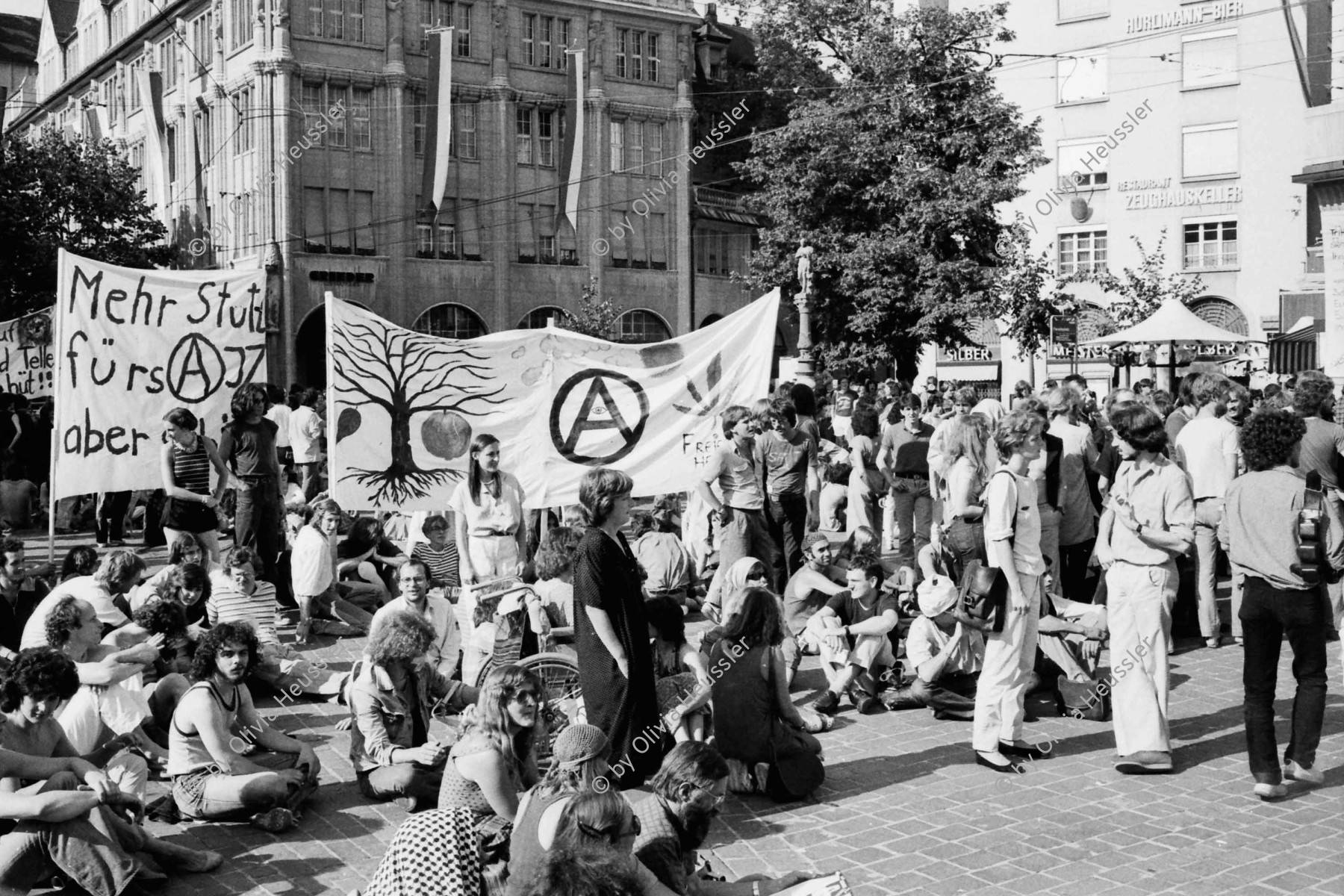 Image of sheet 19800324 photo 10: Das Thema «Einstellung der Strafverfahren» wird von neuem aufgegriffen: Grossdemonstration mit rund 4000 Personen.

Bahnhofstrasse  Bevölkerung und Gaffer. 
Jugendbewegung Bewegig AJZ Zürcher Jugendunruhen Demonstrationen
Demonstration am Nationalfeiertag 1. August 1980 am Paradeplatz und an der Bahnhofstrasse. 
Zürich protest youth movement √