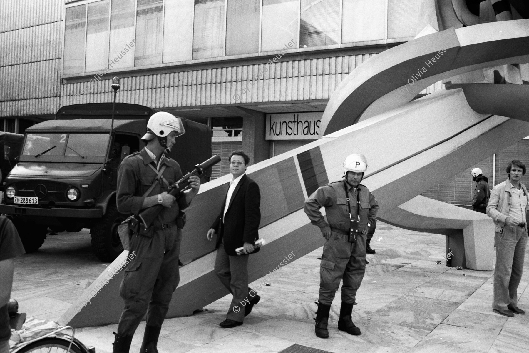 Image of sheet 19800361 photo 17: Demo zur Schliessung des AJZ vor dem Kunsthaus stehen Grenadiere und ihre Fahrzeuge vor der «Fanfare» des Schweizer Künstlers Robert Müller auf dem Zürcher Kunsthaus Platz am Pfauen. 
Jugendbewegung Bewegig AJZ Zürcher Jugendunruhen Demonstrationen
Zürich Youth movement 1980 √