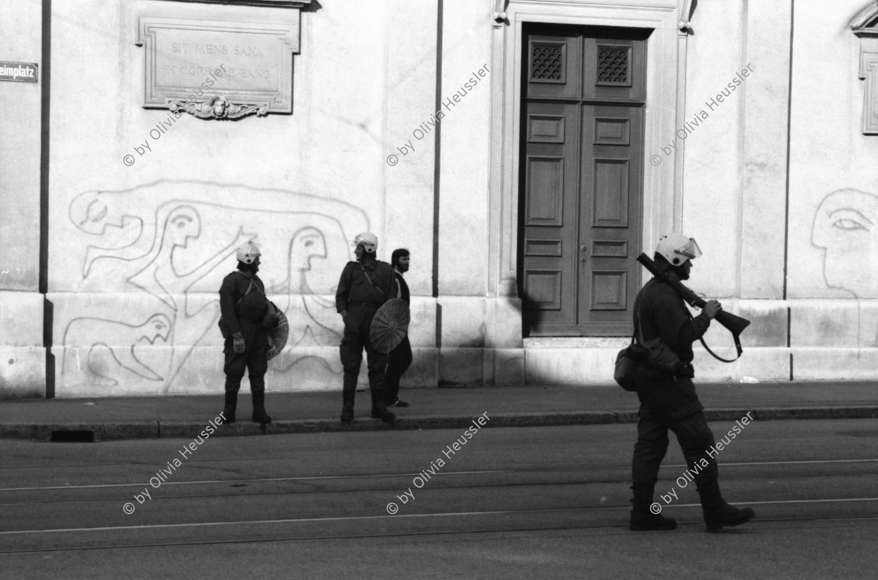 Image of sheet 19800361 photo 23: Demonstration zur Schliessung des AJZ vor dem Kunsthaus stehen Grenadiere und ihre Fahrzeuge. Sie kontrollieren PassantInnen. «Fanfare» des Schweizer Künstlers Robert Müller und Calder Mobile hängt vor dem Zürcher Kunsthaus am Pfauen. Graffittis 'Was gibt der Schwajz ihren rajz.' Mann spielt mit Wasserzuber und Schirm am Brunnen vor dem Franziskaner Hotel im Niederdorf.

Jugendbewegung Bewegig AJZ Zürcher Jugendunruhen Demonstrationen
Zürich Youth movement 1980