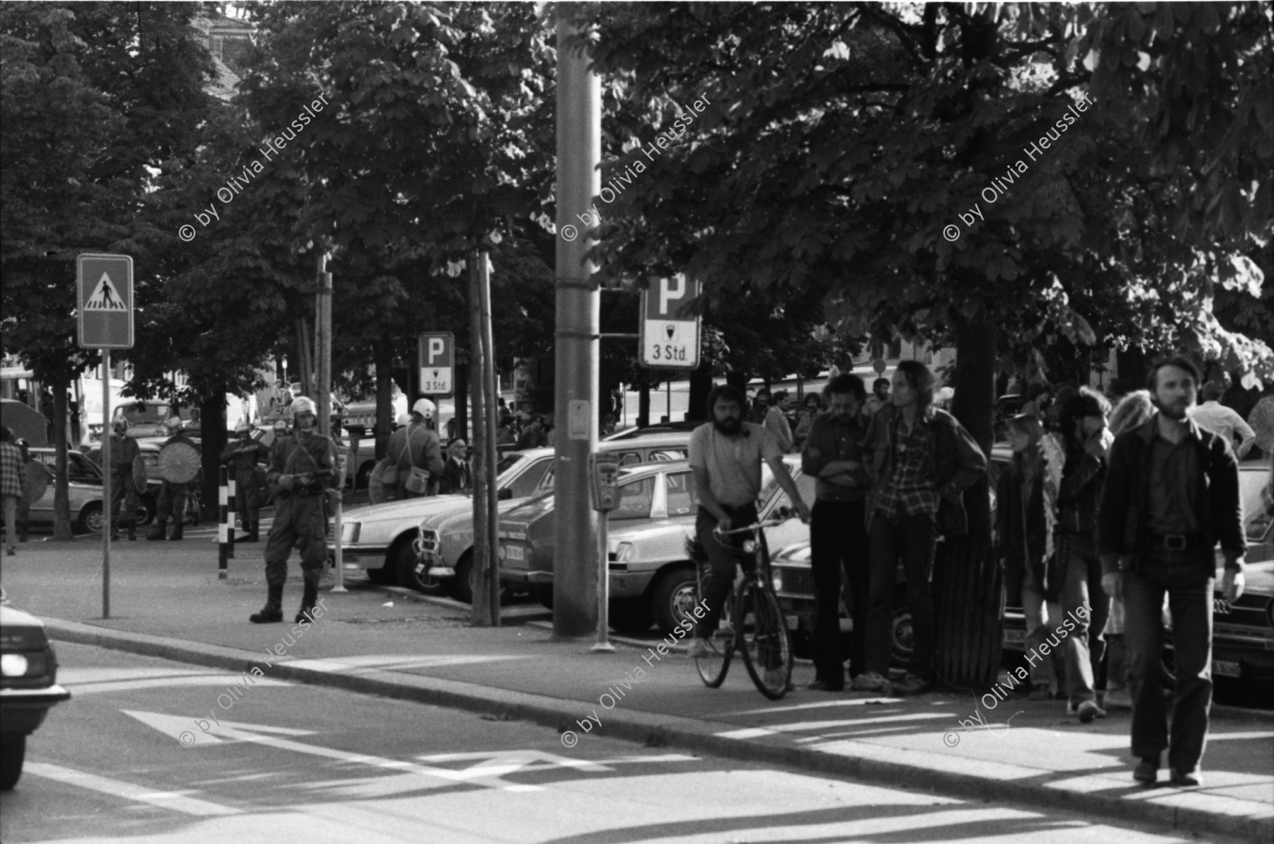 Image of sheet 19800361 photo 25: Demonstration zur Schliessung des AJZ vor dem Kunsthaus stehen Grenadiere und ihre Fahrzeuge. Sie kontrollieren PassantInnen. «Fanfare» des Schweizer Künstlers Robert Müller und Calder Mobile hängt vor dem Zürcher Kunsthaus am Pfauen. Graffittis 'Was gibt der Schwajz ihren rajz.' Mann spielt mit Wasserzuber und Schirm am Brunnen vor dem Franziskaner Hotel im Niederdorf.

Jugendbewegung Bewegig AJZ Zürcher Jugendunruhen Demonstrationen
Zürich Youth movement 1980