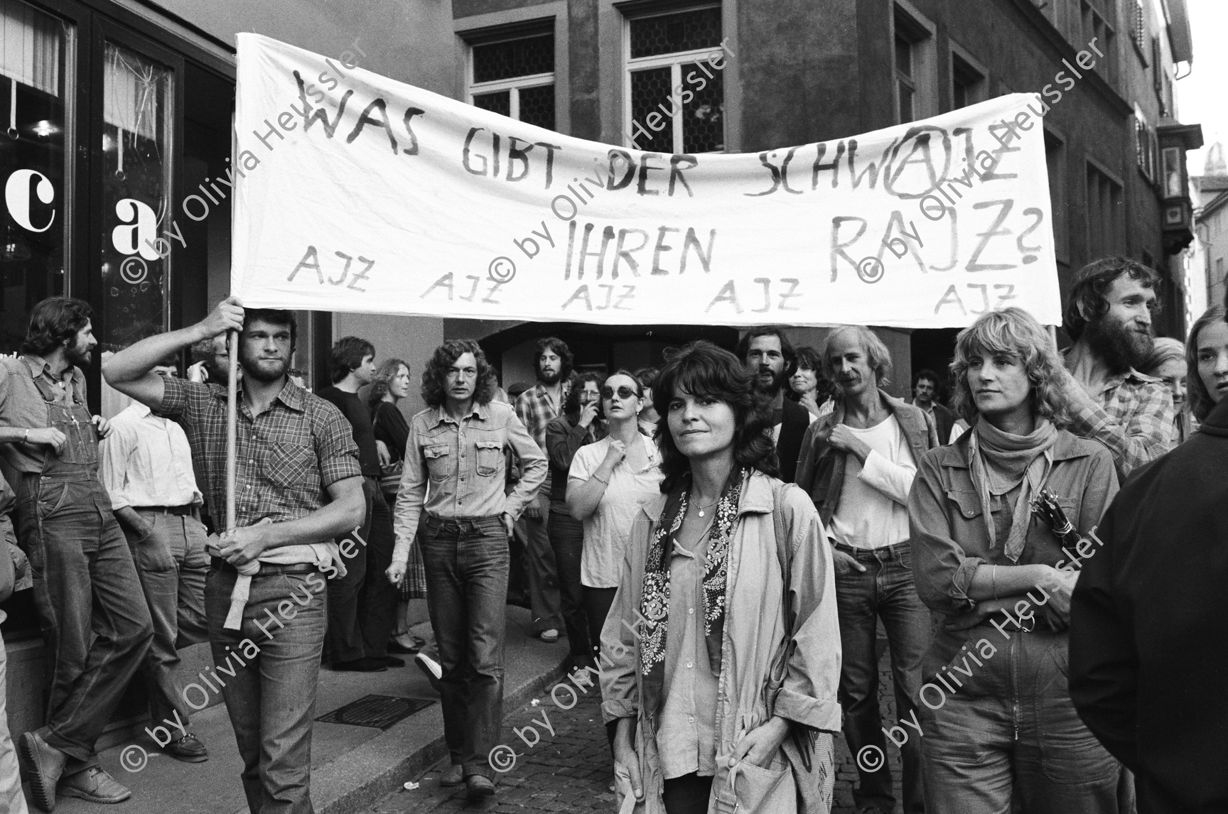 Image of sheet 19800361 photo 26: Demo zur Schliessung des AJZ. Transparent
 'Was gibt der Schwajz ihren rajz.' 
Jugendbewegung Bewegig AJZ Zürcher Jugendunruhen Demonstrationen Zürich Youth movement 1980 √