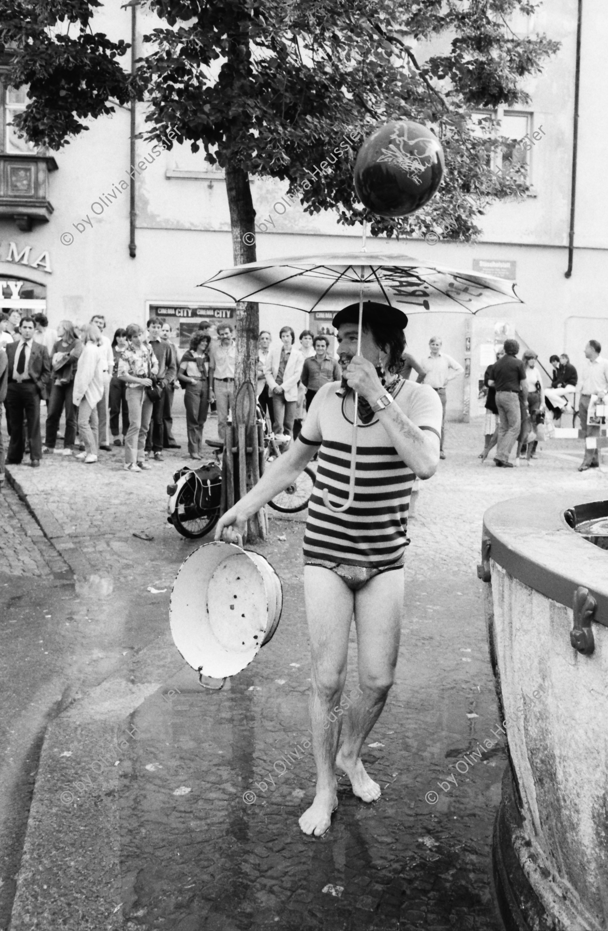 Image of sheet 19800361 photo 36: Demo zur Schliessung des AJZ Demo zur Schliessung des AJZ. Mann spielt mit Wasserzuber und Schirm am Brunnen vor dem Franziskaner Hotel im Niederdorf. Zürcher Innenstadt
Jugendbewegung Bewegig AJZ Zürcher Jugendunruhen Demonstrationen Zürich Youth movement 1980 √
