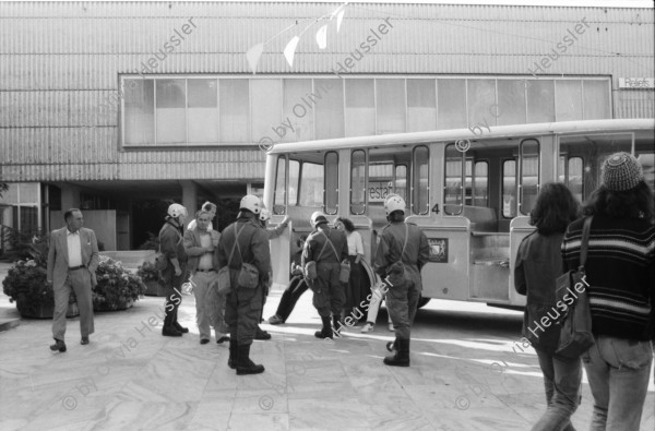 Image of sheet 19800361 photo 8: Passantin wir unter dem Calder Mobile vor dem Kunsthaus Bau von Bührle von Polizei Grenadieren kontrolliert, 1980 Zürich.

Jugendbewegung Bewegig Zürcher Jugendunruhen Demonstrationen Youth movement