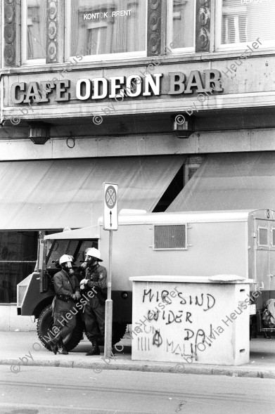 Image of sheet 19800362 photo 8: Polizeibeamte vor dem Café Odeon, Zuerich 1980.
«Mir sind wieder da! Zum IIII Mal!!» gesprayt.
Police Graffiti
Jugendbewegung Bewegig AJZ Zürcher Jugendunruhen Demonstrationen Youth movement 
Belgrade Photo Month 2019, 76 x 114 cm
Exhibition: The eighties. Photobastei 2.0 2020