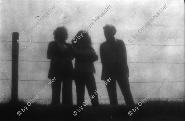 Image of sheet 19800363 photo 0: Silhouette dreier Menschen vor Stacheldraht am Goffersberg vis a vis Schloss Lenzburg, 1980 Kanton Aargau.