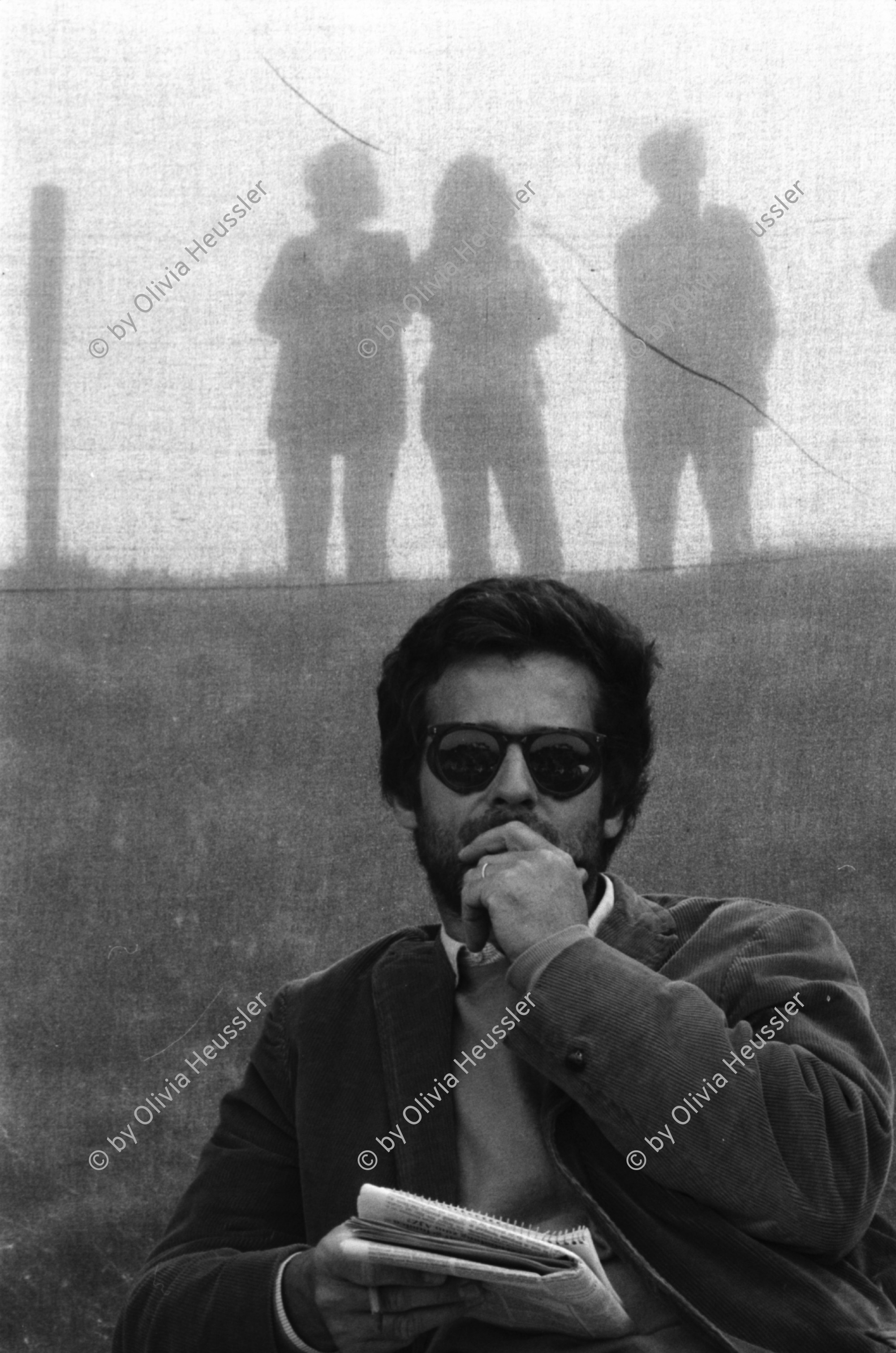 Image of sheet 19800363 photo 3: Journalist Roland Huber und Besucher*Innen. Giuseppe Reichmuth veranstaltet 'Show' auf dem Goffersberg vis à vis Schloss Lenzburg, 1980.
