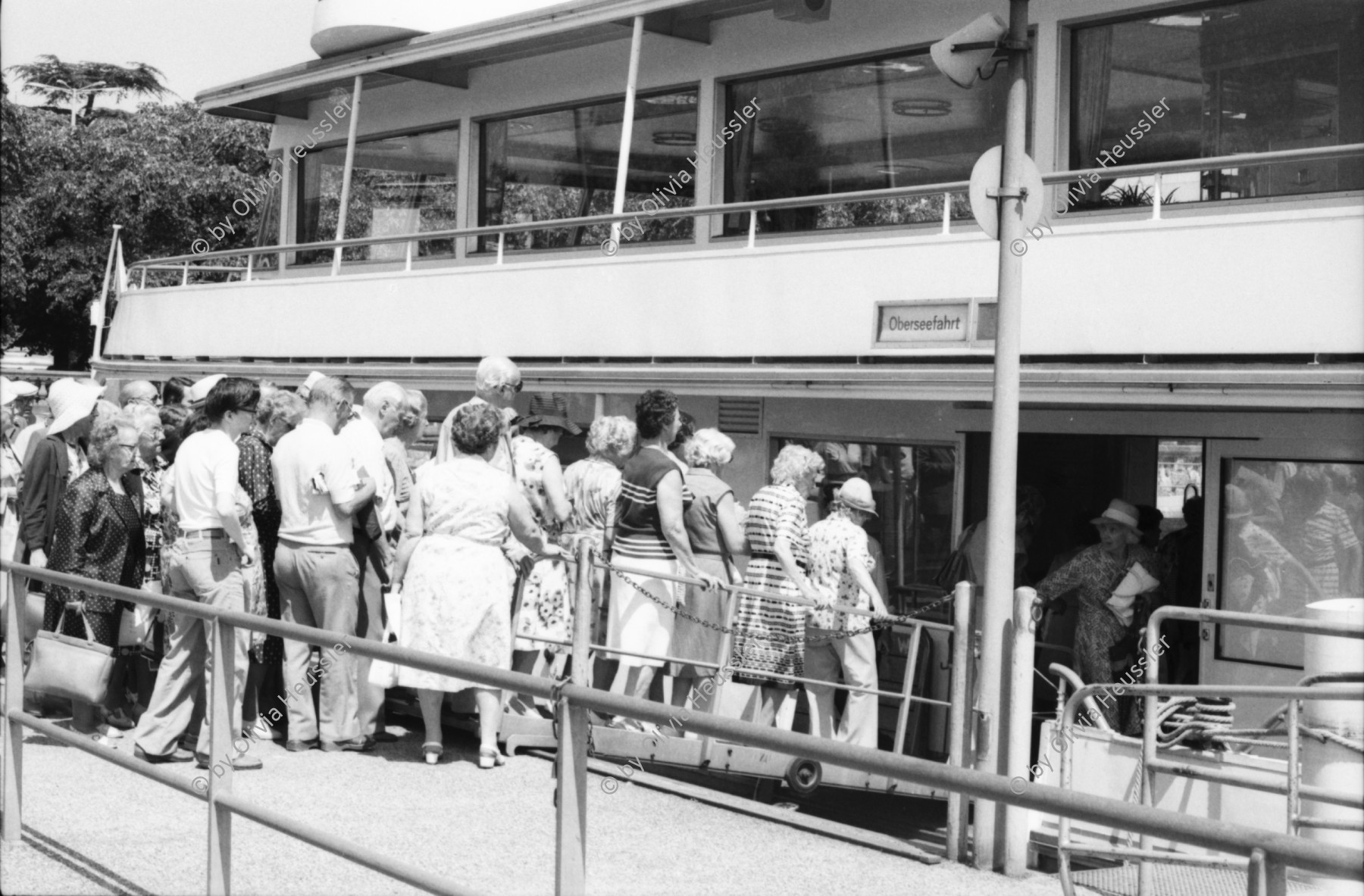 Image of sheet 19800372 photo 17: Dampfschifffahrt auf dem Zürichsee auf der 'Möve' und Wädenswil'. Junge zieht Fisch an Rute aus dem See. Leute beim Sonnenbaden auf Wiese und in Bad. Für Blick. Fischerrute Zürich Schweiz Suisse 1980 Switzerland lake ship steamer