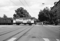 Image of sheet 19800400 photo 10: Kinderwagen  und Spielsachen vor einem Kiosk. Güterwagen überqueren die Strasse.
