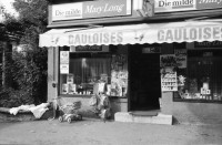 Image of sheet 19800400 photo 7: Kinderwagen  und Spielsachen vor einem Kiosk. Güterwagen überqueren die Strasse.