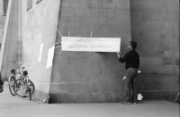 Image of sheet 19800482 photo 13: Ein ziviler Polizeibeamte entfernt ein Plakat an der von Jugendlichen besetzten Fraumünsterkirche in Zürich 1980. 
Jugendbewegung Bewegig AJZ Zürcher Jugendunruhen Demonstrationen