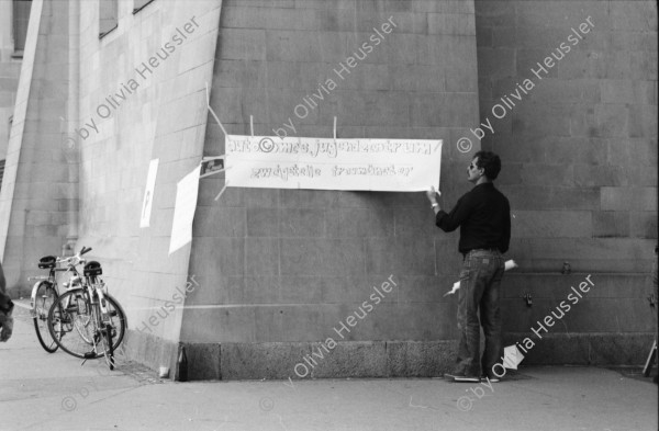 Image of sheet 19800482 photo 13: Ein ziviler Polizeibeamte entfernt ein Plakat an der von Jugendlichen besetzten Fraumünsterkirche in Zürich 1980. 
Jugendbewegung Bewegig AJZ Zürcher Jugendunruhen Demonstrationen