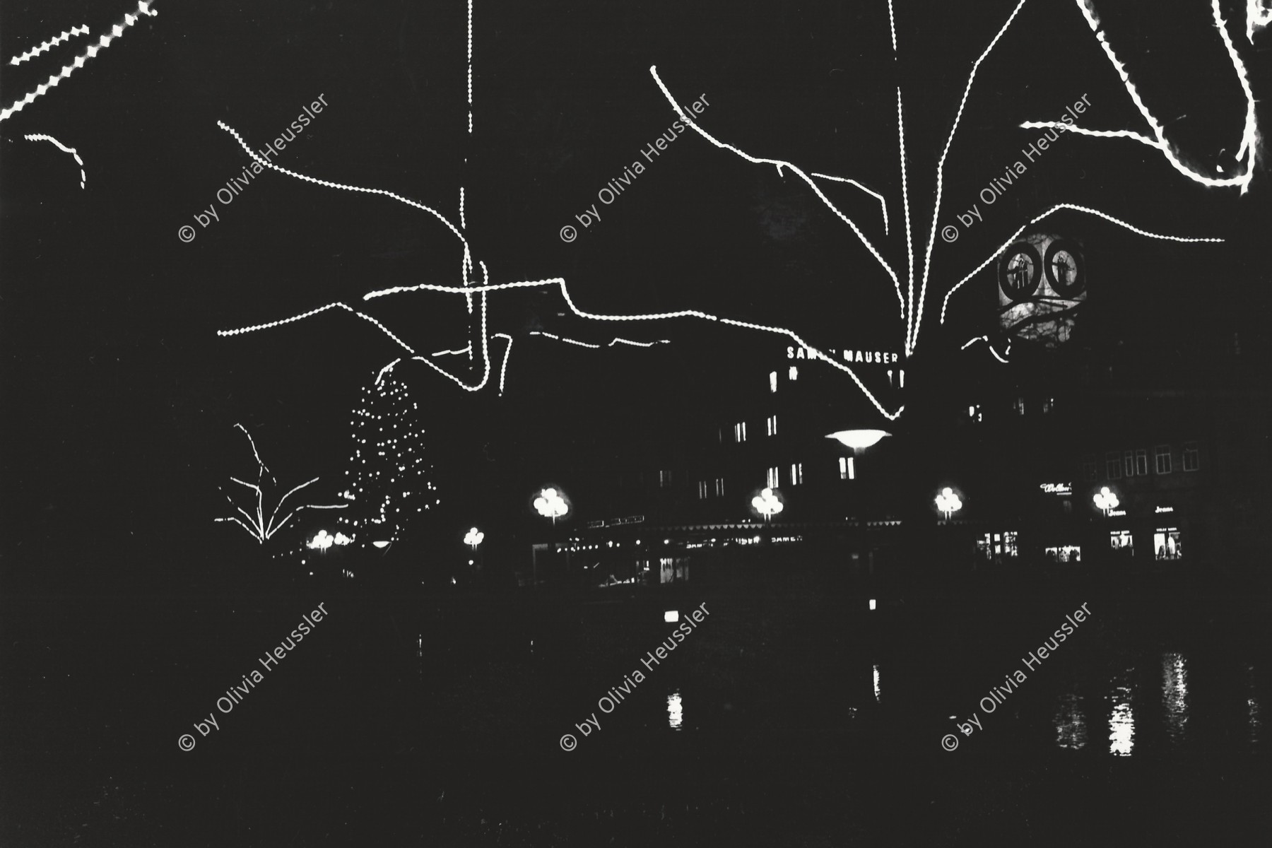 Image of sheet 19800580 photo 5: Weihnachtsbeleuchtung mit Lichter Girlanden an Bäumen dem Limmatquai entlang. Mit Fraumünster Kirche. Zürich 1980 √