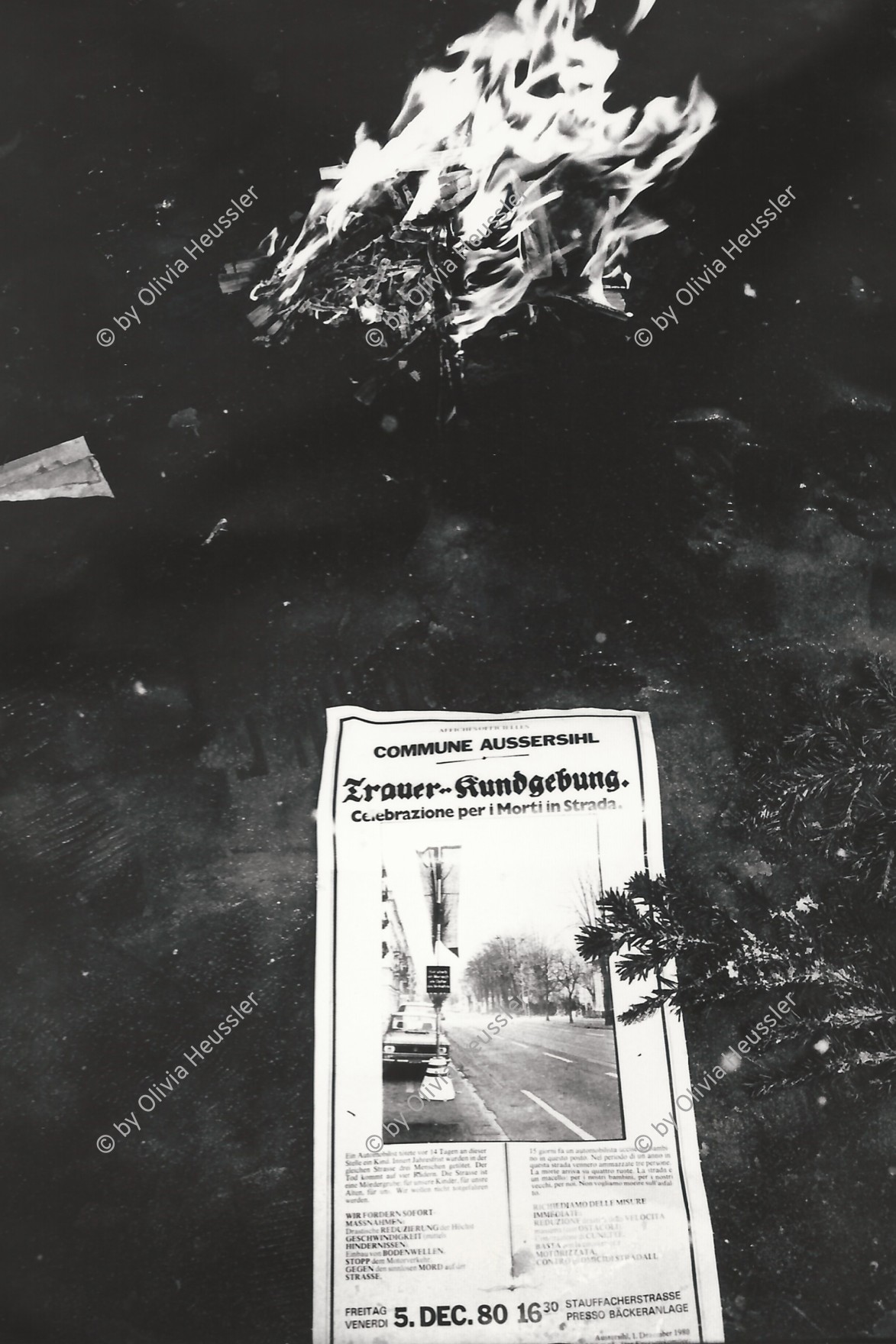 Image of sheet 19800621 photo 16: Die Aktionsgruppe Luft und Lärm (mit Gabriella Eberle gest. 1981 an der selben Stelle ein Jahr später) manifestiert gegen zu hohes Verkehrsaufkommen im Kreis 4 an der Stauffacherstrasse in der Nacht mit Schnee und Feuer. Schneeflocken fliegen auf die den Boden. Schwarze Fahnen im Wind. Ein Autofressendes Monster steht da. Die Polizei steht schon bereit. CV Jugendbewegung Bewegig AJZ Zürcher Jugendunruhen Demonstrationen Youth movement Zürich 1980 √ Kreis 4 Aussersihl