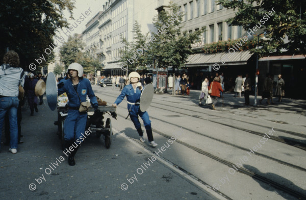 Image of sheet 19803000 photo 25: Jugendliche protestieren in einer Polit Performance, mit Korb-Schilder und Helm als Polizei Grenadiere verkleidet an der Bahnhofstrasse 1980 in Zuerich.
Kreativ Action