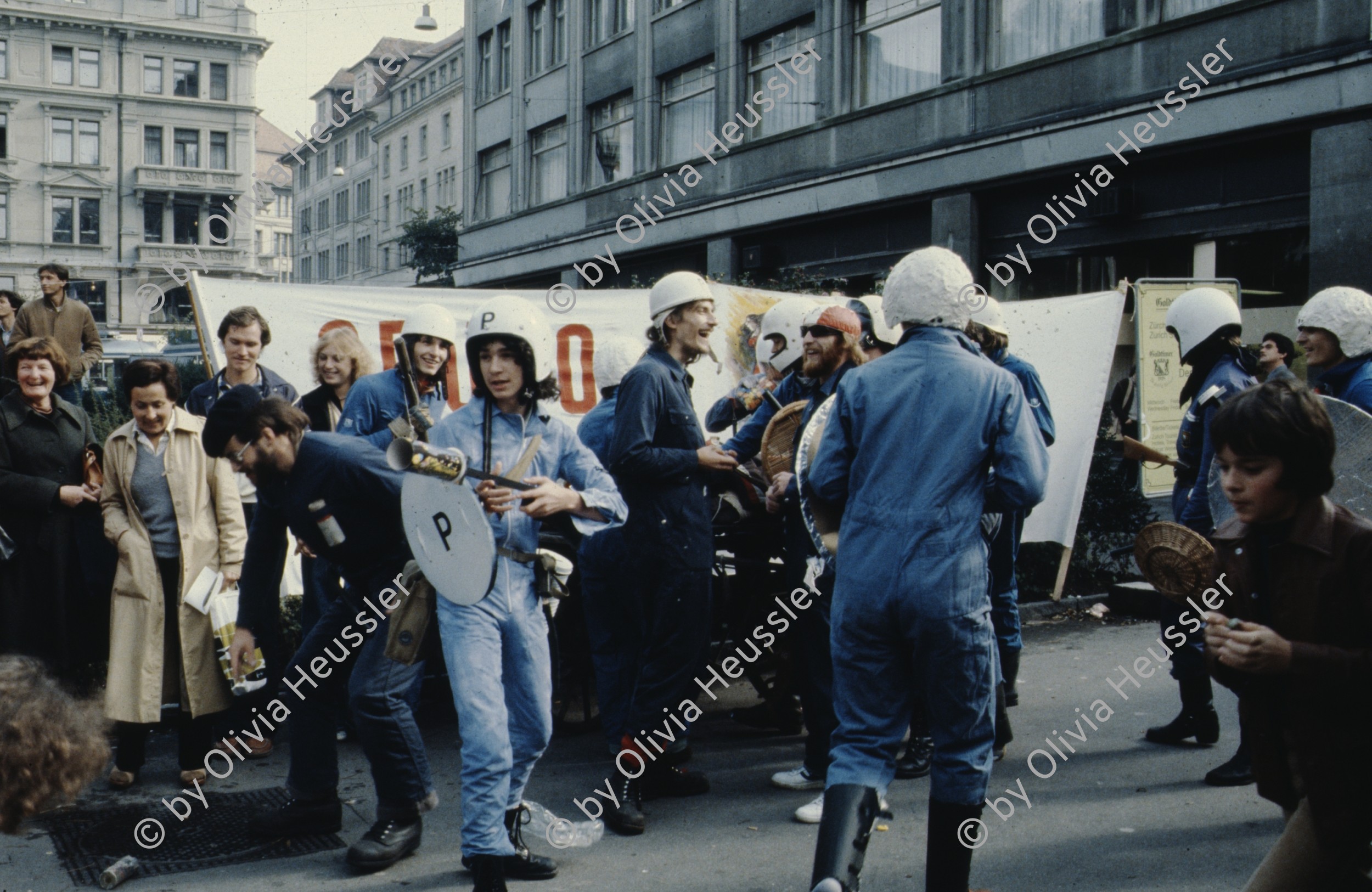 Image of sheet 19803000 photo 27: Jugendliche protestieren in einer Polit Performance, mit Korb-Schilder und Helm als Polizei Grenadiere verkleidet an der Bahnhofstrasse 1980 in Zuerich.
Kreativ Action
creative Action Jugendbewegung Youth Movement Protest Art Polit Performance