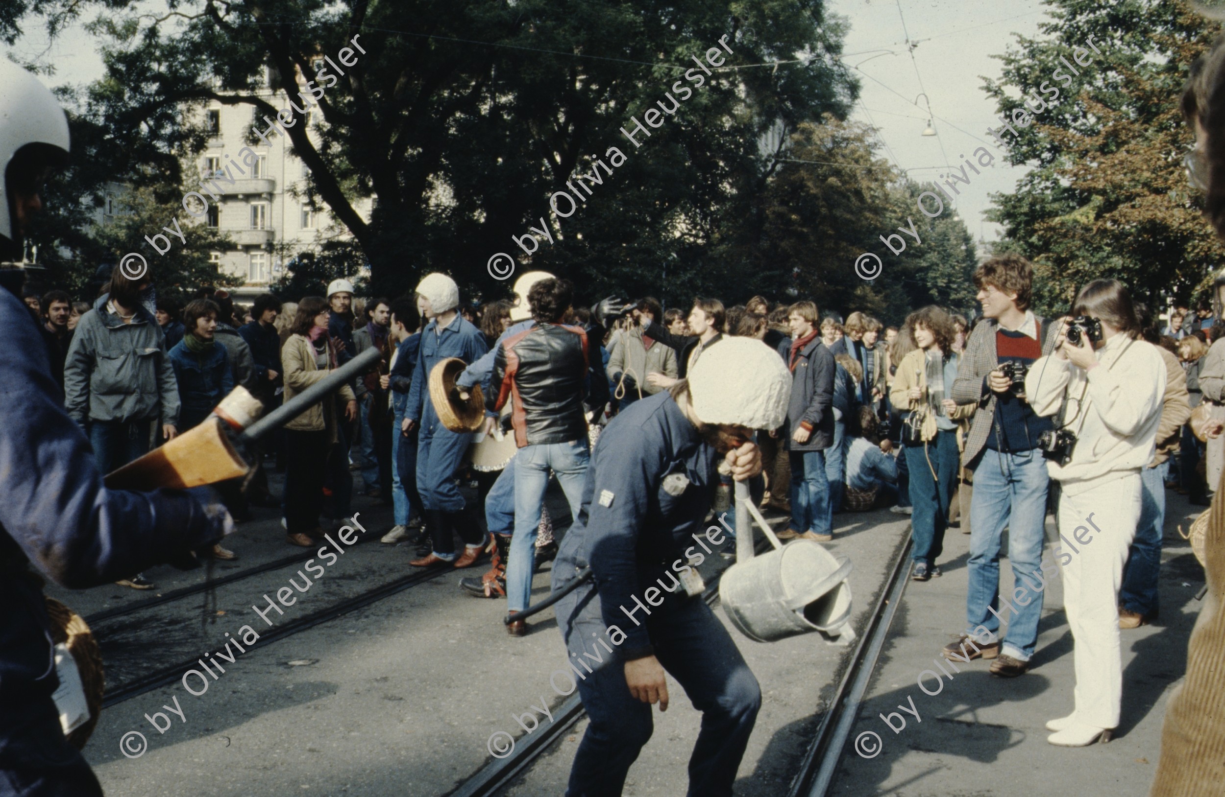 Image of sheet 19803000 photo 28: Jugendliche protestieren in einer Polit Performance, mit Korb-Schilder und Helm als Polizei Grenadiere verkleidet an der Bahnhofstrasse 1980 in Zuerich.
Kreativ Action