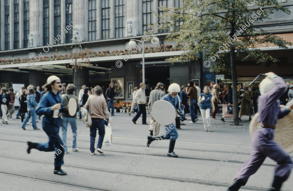 Image of sheet 19803000 photo 32: Jugendliche protestieren in einer Polit Performance, mit Korb-Schilder und Helm als Polizei Grenadiere verkleidet an der Bahnhofstrasse 1980 in Zuerich.
Kreativ Action