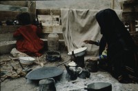 Image of sheet 19803002 photo 118: Beduin Woman with child preparing food in the Sinai Desert, Israel 1980.