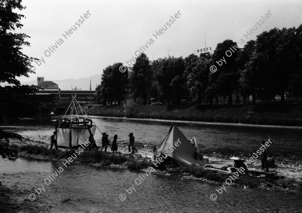 Image of sheet 19810191 photo 8: Chaotikon in der Sihl Fluss Wasser Protest gegen Wohnungsnot Wohn Installation Zürich Feuer 

Baraken siedlung auf Pfosten, Küche  housing 1981 Switzerland swiss Schweiz Europe youth movement Wohnen