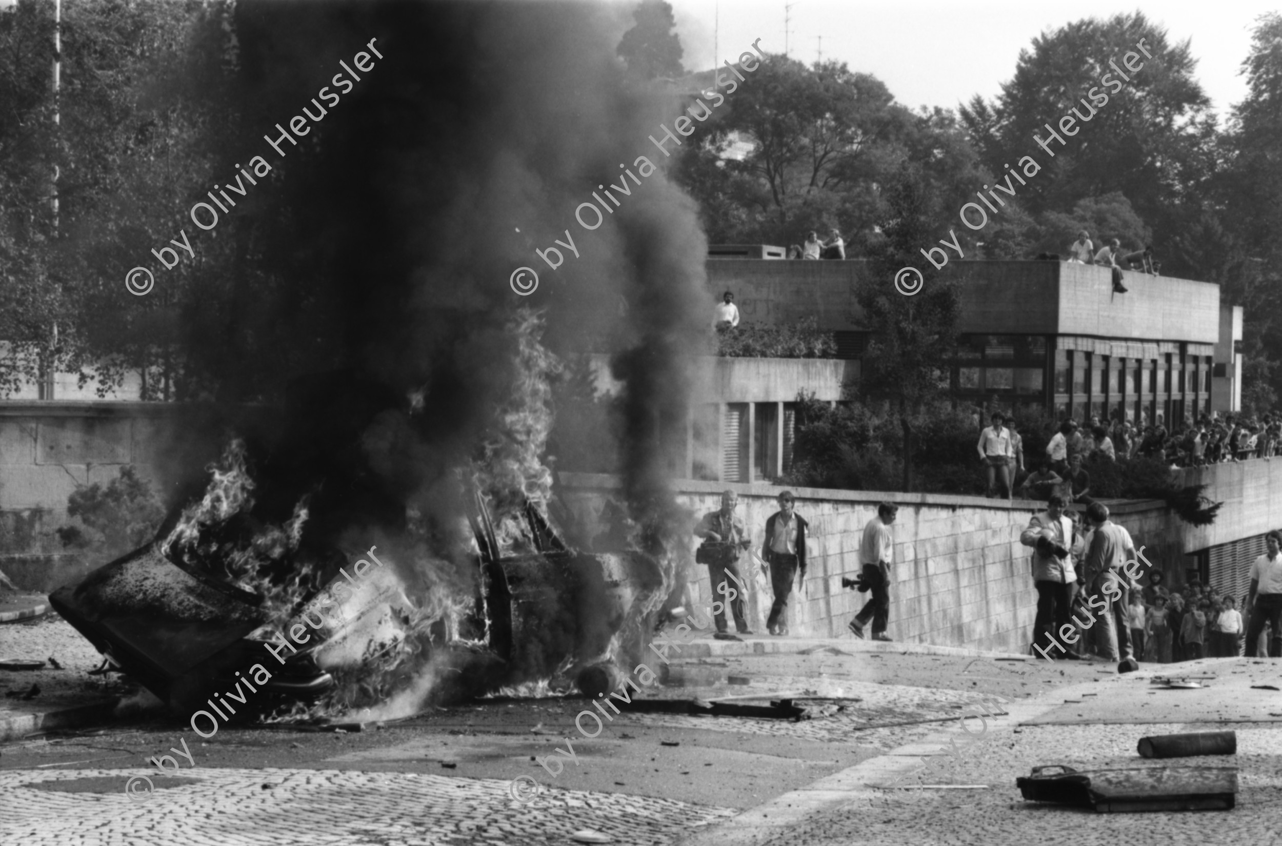 Image of sheet 19810440 photo 30: frtsg 810430 Espion lève-toi. Directed by Yves Boisset. With Lino Ventura, Michel Piccoli, Bruno Cremer. 1982
Polizei Motorrad. Mercedes Auto Sprengung Feuerwehr löscht. Die Heckschutz Scheibe hat mir fast den Kopf abgerissen. Sie landete oben im Garten des zoologischen Institutes neben einem Delphin aus Stein. Die Sprengung war zu stark. Zürich 1981
