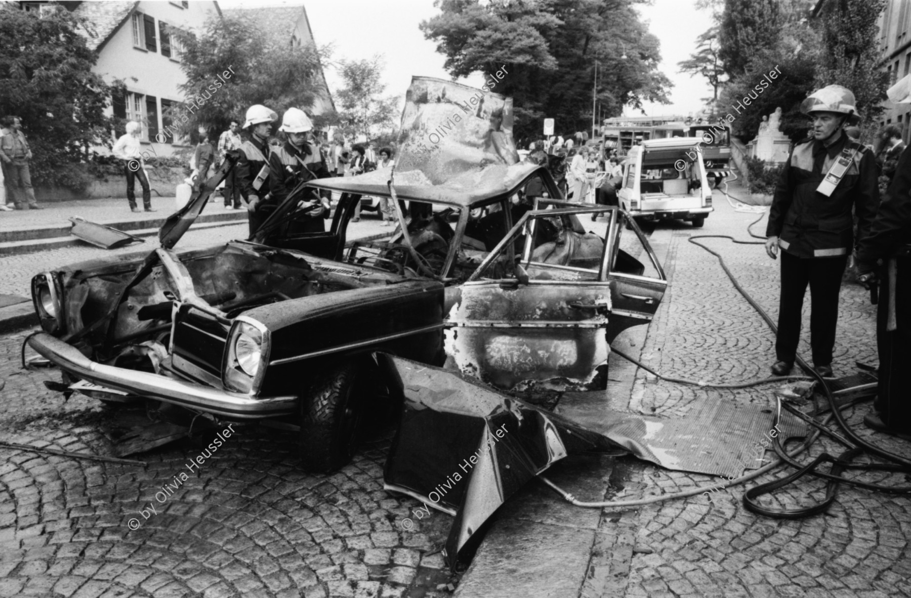 Image of sheet 19810470 photo 4: Feuerwehr löscht brennender Mercedes Benz auf Filmset Yves Poisset. Zürich 1981