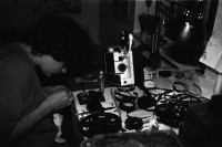 Image of sheet 19810571 photo 15: Christoph Schuler während Film Produktion Super 8 Hamburger Film. Weinbergstrasse 84 Flasche. Filmspuhlen liegen überall umher Zürich 1981