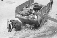 Image of sheet 19820030 photo 19: Container mit Abfall, Mann kniet vor einem Ofen im autonomen Jugendzentrum AJZ im Winter in Zuerich 1982.
Jugendbewegung Zürich