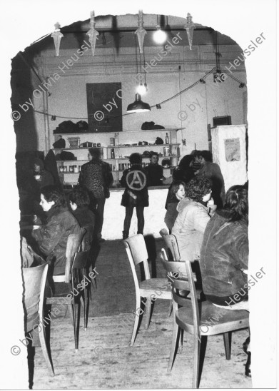 Image of sheet 19820040 photo 16: Kreis fünf 5 Swiss Switzerland Europe people persons graffiti Women Woman party occupied house housing Bewegung smoke cigars table konsumierung Zusammenleben Jugendbewegung Jugendzentrum Jugendhaus Anarchist A Jacket leather Punk music chairs Bar
Anfangs Januar 1982
Heinz Nigg:
Nach der 14-tägigen provisorischen Wiedereröffnung diskutieren rund 300 Bewegte an einer VV, ob das AJZ weiterhin geöffnet bleiben soll: Die Fixer und Hänger setzen sich vehement gegen eine Schliessung zur Wehr; die meisten Arbeitsgruppen plädieren für die Einstellung des Betriebs.