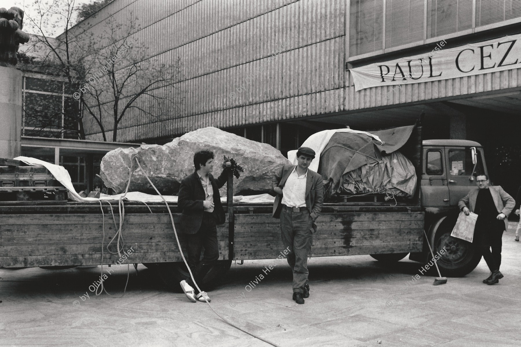 Image of sheet 19820190 photo 10: Der Künstler Mike Hentz (li), Karel Dudesek (mi) und Peter Preissle (re.) mit dem Projekt Minus Delta t vor der Abfahrt nach Bangkok mit einem tonnenschweren Findling auf dem Lastwagen.

Die Gruppe Minus Delta T ist bekannt für Ihre Performances/Aktonen. Die Aktion Stone - der Stein kommt aus dem Steinbruch wo auch die Steine von Stonehenge gebrochen wurden. Man konnte Kiloweise sich an dem Stein beteiligen, der Stein ist auf dem Landweg in den Himalaya gefahren worden, wor er noch heute ist. Steinaustausch -
Kulturaustausch.

Kunsthaus Zürich. 1982 √